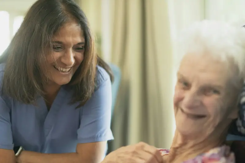A nurse sharing a laugh with an older woman